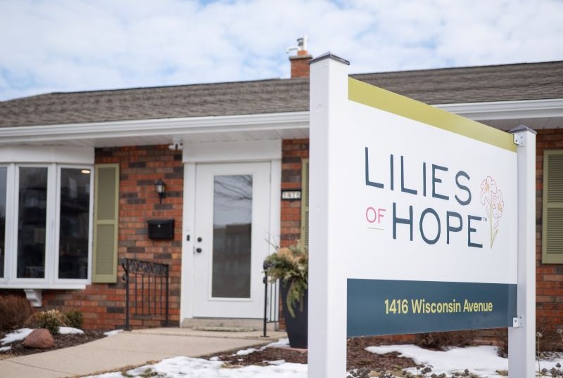 Sign for Lilies of Hope at 1416 Wisconsin Avenue in front of a brick building.